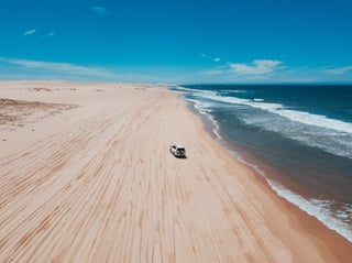 Un 4x4 en una playa con olas